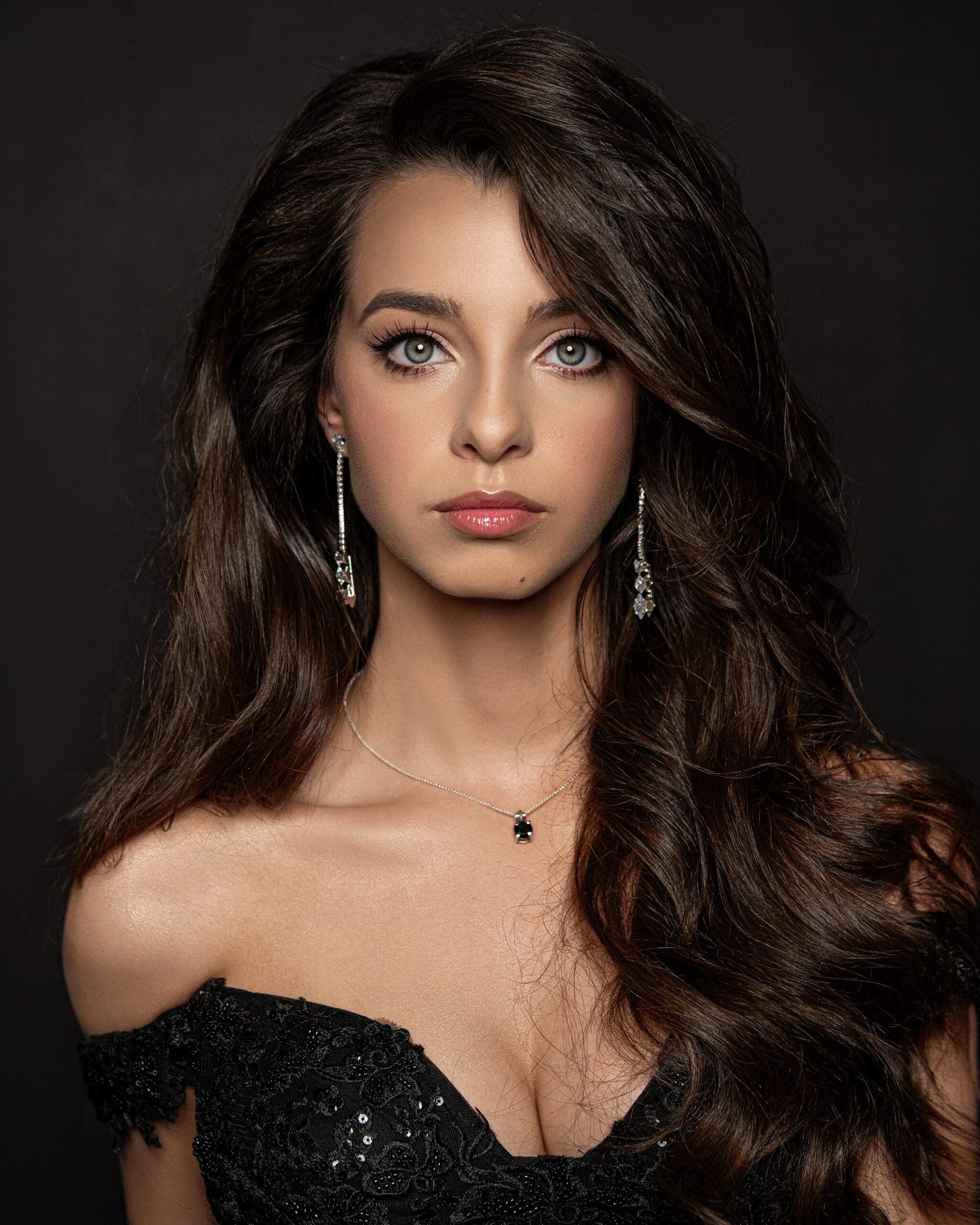 Woman with long, voluminous curls styled for an evening look